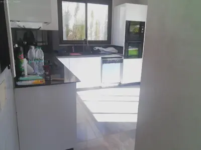a kitchen with white cabinets and a black counter top at Villa GHMAT in Aghmat