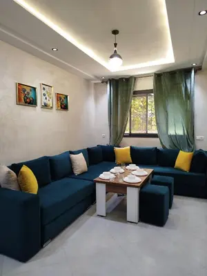 a living room with a blue couch and a table at Le refuge de Vittel 3 in Ifrane