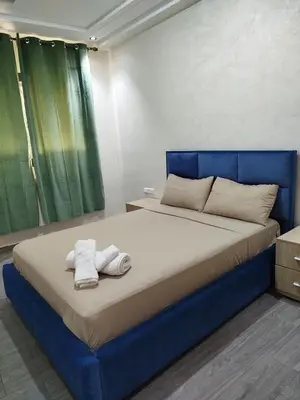 a bedroom with a blue bed with towels on it at Le refuge de Vittel 3 in Ifrane