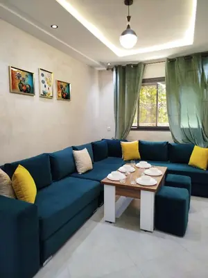 a living room with a blue couch and a table at Le refuge de Vittel 3 in Ifrane
