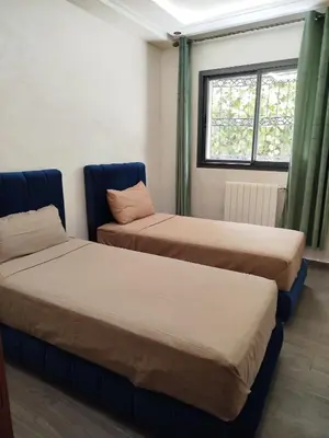 two beds sitting in a room with a window at Le refuge de Vittel 3 in Ifrane