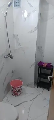 a bathroom with a toilet and a bucket on the floor at Le refuge de Vittel in Ifrane