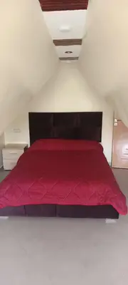 a bedroom with a red bed in a attic at Le refuge de Vittel in Ifrane