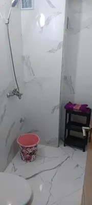 a bathroom with a shower and a bucket on the floor at Le refuge de Vittel in Ifrane