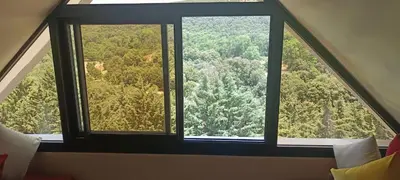 a large window with a view of a forest at Le refuge de Vittel in Ifrane