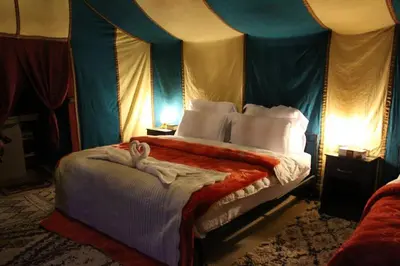a bedroom with a large bed with a blue canopy at Starlight Mirage Camp in Lac Yasmins