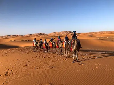 a group of people riding horses in the desert at Starlight Mirage Camp in Lac Yasmins