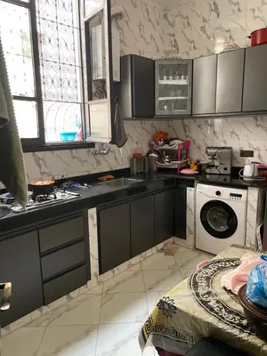 a kitchen with a sink and a washing machine at Chambre à deux lit in Fès