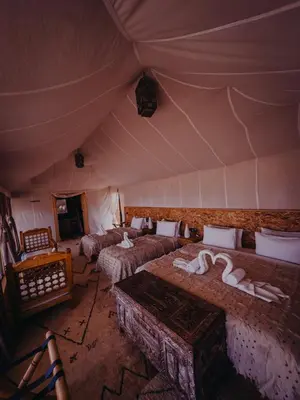 a room with four beds in a tent at Desert luxury tents in Merzouga