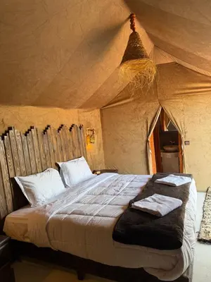a bedroom with a bed in a tent at Desert luxury tents in Merzouga