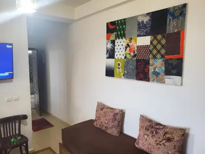 a living room with a couch and a painting on the wall at le bon coin in Ifrane