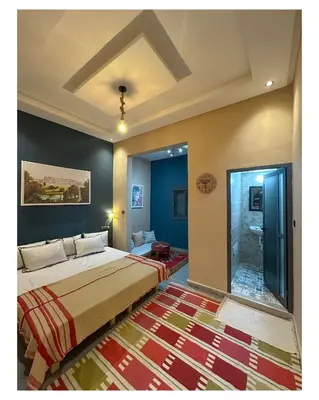 a bedroom with a large bed and a bathroom at Tigami N-Laman in Iskhissane