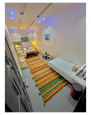 a living room with a bed and a rug at Tigami N-Laman in Iskhissane