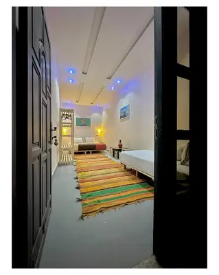 a hallway with a bed and a room with a rug at Tigami N-Laman in Iskhissane