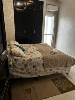 a bedroom with a bed with a blanket and a window at Beautiful large apartment in Fès
