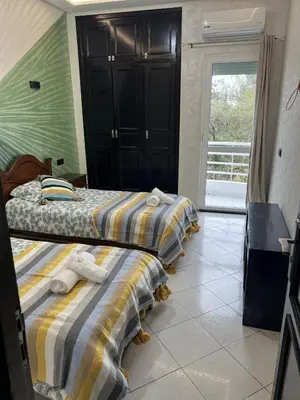 two twin beds in a room with a window at Beautiful large apartment in Fès