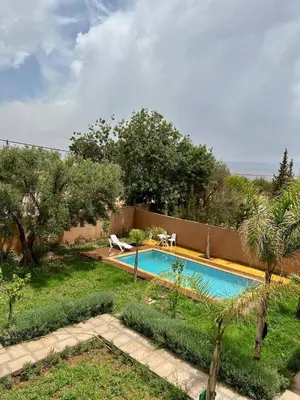 a swimming pool in a yard next to the ocean at Villa Zine in Aït Namous
