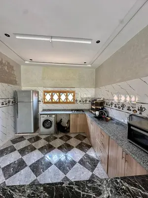 a large kitchen with a checkered floor at Villa Zine in Aït Namous
