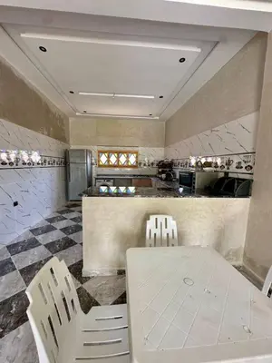a kitchen with a white table and two chairs at Villa Zine in Aït Namous