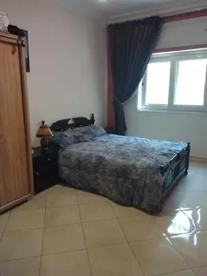 a bedroom with a bed and a dresser and a window at Apartment Rabat Agdal in Oulad Akkou