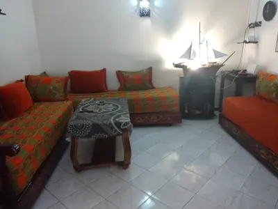 a living room with a couch and a table and a piano at Apartment Rabat Agdal in Oulad Akkou