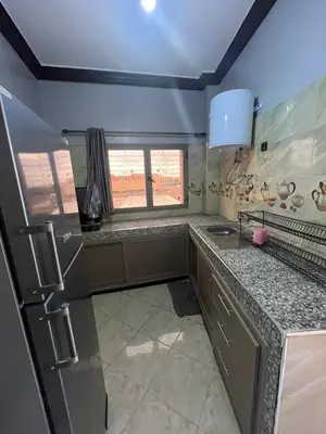 a kitchen with a stainless steel refrigerator and a window at desert appartement in Merzouga
