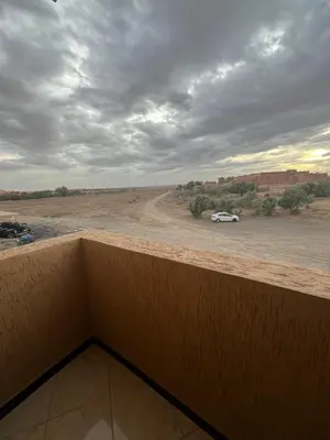 a view of a desert with a car on a dirt road at desert appartement in Merzouga