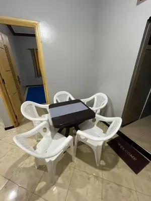 two white chairs and a table in a room at desert appartement in Merzouga
