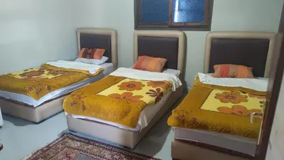 three beds in a room with a room with rugs at Villa de rêve in Bine el Ouidane