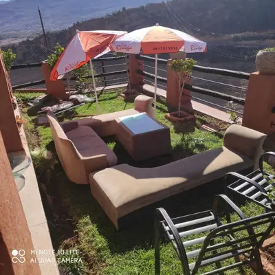 a patio with a couch and an umbrella at Villa de rêve in Bine el Ouidane