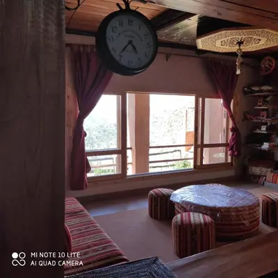 a clock hanging on a wall next to a window at Villa de rêve in Bine el Ouidane