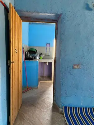 a blue kitchen with a counter and a blue wall at Housse stander merzouga in Merzouga