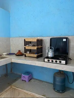 a counter with a microwave and a television on it at Housse stander merzouga in Merzouga
