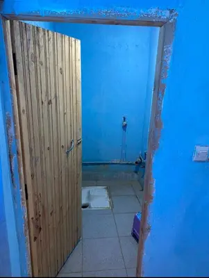 a bathroom with a door in a blue room at Housse stander merzouga in Merzouga