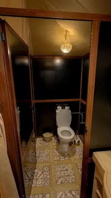 a small bathroom with a toilet in a room at Arabian Nights Desert Camp Merzouga in Lac Yasmins