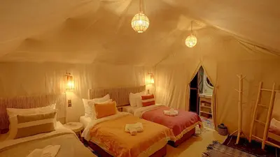 a bedroom with two beds in a tent at Arabian Nights Desert Camp Merzouga in Lac Yasmins