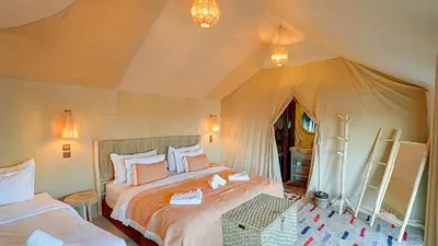 a bedroom with two beds in a tent at Arabian Nights Desert Camp Merzouga in Lac Yasmins