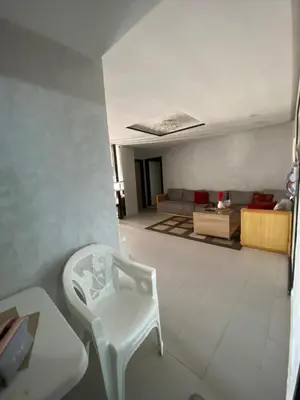 a living room with a white chair and a couch at Appartement lux meublé in Ouarzazate