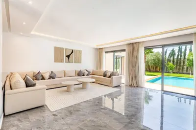 a living room with white furniture and a pool at Villa Maryam , Élégance et calme & piscine privée in Marrakech