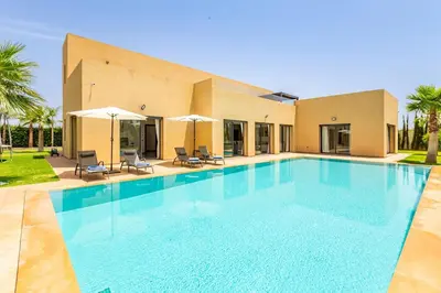 a large swimming pool in front of a house at Villa Maryam , Élégance et calme & piscine privée in Marrakech