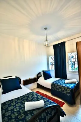 a hotel room with two beds and a window at Charmant appartement avec Wifi in Fès