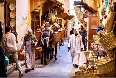a group of people walking down a street with a horse drawn carriage at Charmant appartement avec Wifi in Fès