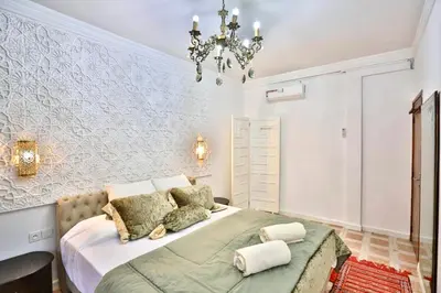 a bedroom with a bed and a chandelier at Charmant appartement avec Wifi in Fès