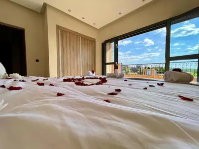 a bedroom with a bed with red rose petals on it at Shams 2 in Sbiti
