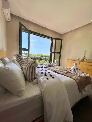 a bedroom with a large bed with a large window at Shams 2 in Sbiti