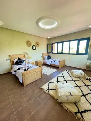 a bedroom with two beds and a rug at Shams 2 in Sbiti