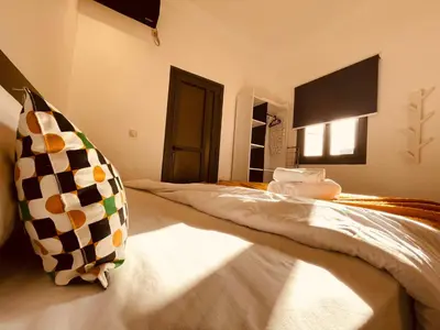 a bedroom with a bed with a comforter at ZyonFamily in Ouarzazate