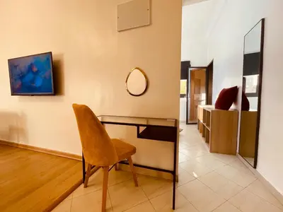 a desk with a chair and a mirror in a room at ZyonFamily in Ouarzazate