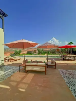 a group of benches and umbrellas on a patio at Maison blanche in Sbiti