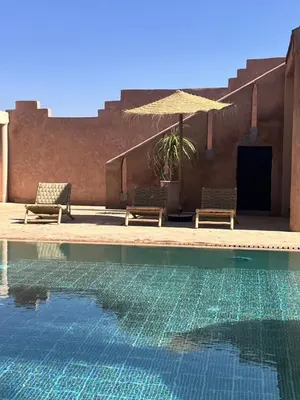 a swimming pool with two chairs and an umbrella at Villa 4 chambres avec grande piscine privée in Marrakech
